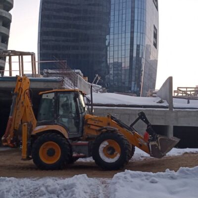 Экскаватор КДСПЕЦАВТО выполняет рытье траншеи на строительной площадке